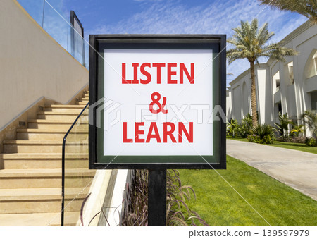 Listen and learn words symbol. Concept words Listen and learn on beautiful white sign. Beautiful hotel garden blue sky background. Business listen and learn support concept. Copy space. Listen and learn words symbol. Concept words Listen and learn on beautiful white sign. Beautiful hotel garden blue sky background. Business listen and learn support concept. Copy space. 139597979