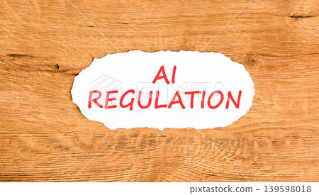 AI regulation symbol. Concept words AI artificial intelligence regulation on beautiful white paper. Beautiful wooden background. Business AI artificial intelligence regulation concept. Copy space. AI regulation symbol. Concept words AI artificial intelligence regulation on beautiful white paper. Beautiful wooden background. Business AI artificial intelligence regulation concept. Copy space. 139598018