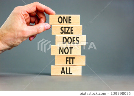 One size does not fit all symbol. Concept words One size does not fit all on wooden stick. Beautiful grey background. Businessman hand. One size does not fit all business concept. Copy space. 139598055