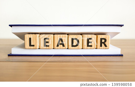 Leadership and leader symbol. Concept word Leader on beautiful wooden blocks in beautiful book. Beautiful wooden table white background. Business leader and leadership concept. Copy space. Leadership and leader symbol. Concept word Leader on beautiful wooden blocks in beautiful book. Beautiful wooden table white background. Business leader and leadership concept. Copy space. 139598058