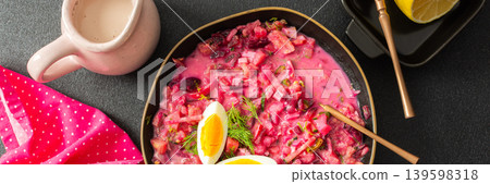 A colorful bowl of beet soup features chopped vegetables, sliced eggs, and fresh herbs. The setting includes a jug of cream, a lemon, and radishes, creating a cozy atmosphere, banner A colorful bowl of beet soup features chopped vegetables, sliced eggs, and fresh herbs. The setting includes a jug of cream, a lemon, and radishes, creating a cozy atmosphere, banner 139598318
