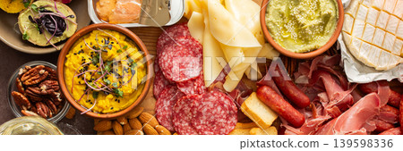 This festive spread features an array of cheese, cured meats, hummus, nuts, and fresh vegetables. Perfect for sharing at a casual get-together or celebration with friends, banner This festive spread features an array of cheese, cured meats, hummus, nuts, and fresh vegetables. Perfect for sharing at a casual get-together or celebration with friends, banner 139598336