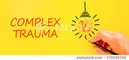 Complex trauma symbol. Concept words Complex trauma on beautiful yellow paper. Beautiful yellow background. Light bulb icon. Psychologist hand. Psychological complex trauma support concept. Copy space Complex trauma symbol. Concept words Complex trauma on beautiful yellow paper. Beautiful yellow background. Light bulb icon. Psychologist hand. Psychological complex trauma support concept. Copy space 139598349