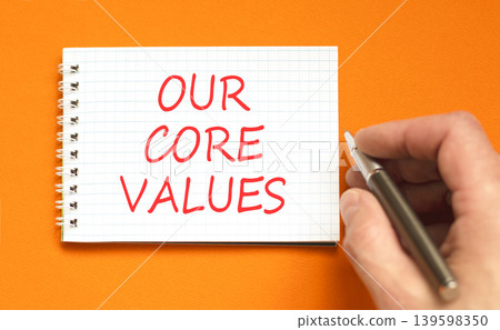 Our core values words symbol. Concept words Our core values on beautiful white note. Beautiful orange background. Businessman hand. Business our core values motivational support concept. Copy space. Our core values words symbol. Concept words Our core values on beautiful white note. Beautiful orange background. Businessman hand. Business our core values motivational support concept. Copy space. 139598350
