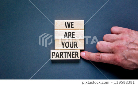 We are your partner symbol. Concept words We are your partner on beautiful wooden blocks. Beautiful grey background. Businessman hand. Business motivational we are your partner concept. Copy space. 139598391