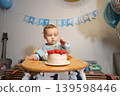 Toddler Baby boy taking candle from his birthday cake. First birthday family celebration. Child celebrates birthday with cake and decorations at home with balloons and decoration. 139598446