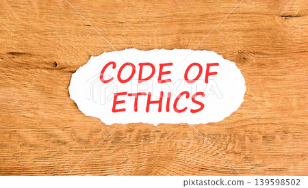 Code of ethics words symbol. Concept words Code of ethics on beautiful white paper. Beautiful wooden background. Business Code of ethics concept. Copy space. Code of ethics words symbol. Concept words Code of ethics on beautiful white paper. Beautiful wooden background. Business Code of ethics concept. Copy space. 139598502