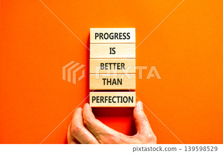 Progress or perfection words symbol. Concept words Progress is better than perfection on beautiful wooden blocks. Beautiful orange paper background. Business progress or perfection concept. Copy space Progress or perfection words symbol. Concept words Progress is better than perfection on beautiful wooden blocks. Beautiful orange paper background. Business progress or perfection concept. Copy space 139598529