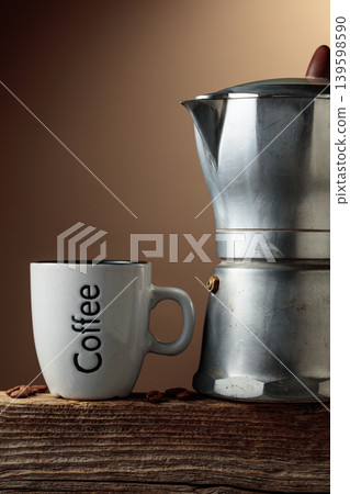 Cup of black coffee and classic Italian aluminium moka pot on an old wooden table. Cup of black coffee and classic Italian aluminium moka pot on an old wooden table. 139598590