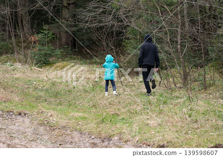 Exploring nature together on a tranquil afternoon stroll through the forest with a child and caregiver enjoying the serenity of the outdoors and its surroundings Exploring nature together on a tranquil afternoon stroll through the forest with a child and caregiver enjoying the serenity of the outdoors and its surroundings 139598607