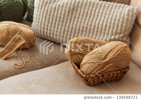 Closeup Knitting Setup with Yarn Basket and Cozy Sofa Closeup Knitting Setup with Yarn Basket and Cozy Sofa 139598721
