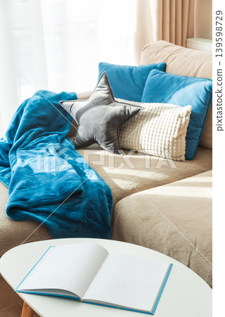 Festive Living Room with Cushions, Blue Blanket, and Open Book Festive Living Room with Cushions, Blue Blanket, and Open Book 139598729