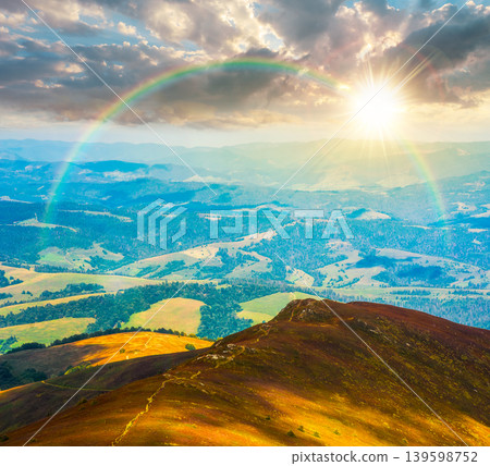 sunset over mountainous countryside scenery. view of cloudy sky above the valley. colorful meadows and trees on hill in dappled light. beautiful nature scenery of carpathians. weather with rainbow sunset over mountainous countryside scenery. view of cloudy sky above the valley. colorful meadows and trees on hill in dappled light. beautiful nature scenery of carpathians. weather with rainbow 139598752