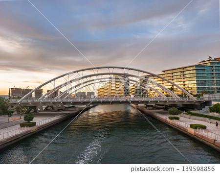 Modern Bridge Over Waterway at Al Raha Beach, Abu Dhabi, UAE During Sunset Modern Bridge Over Waterway at Al Raha Beach, Abu Dhabi, UAE During Sunset 139598856
