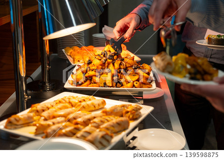 Guests serving roasted potato with mushroom and grilled chicken rolls Guests serving roasted potato with mushroom and grilled chicken rolls 139598875