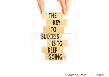 Success and keep going symbol. Concept words The key to success is to keep going on beautiful wooden blocks. Beautiful white paper background. Business success and keep going concept. Copy space. Success and keep going symbol. Concept words The key to success is to keep going on beautiful wooden blocks. Beautiful white paper background. Business success and keep going concept. Copy space. 139598989