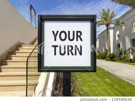 Your turn words symbol. Concept words Your turn on beautiful white sign. Beautiful hotel garden blue sky background. Business your turn motivational support concept. Copy space. 139599030
