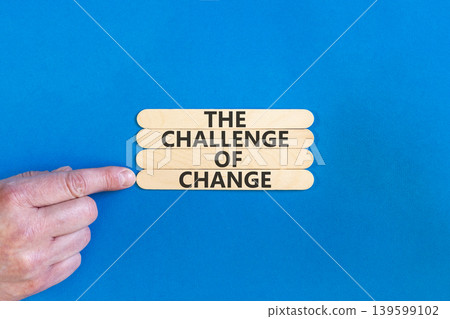 The challenge of change symbol. Concept words The challenge of change on beautiful wooden sticks. Beautiful blue background. Businessman hand. Business the challenge of change concept. Copy space. The challenge of change symbol. Concept words The challenge of change on beautiful wooden sticks. Beautiful blue background. Businessman hand. Business the challenge of change concept. Copy space. 139599102
