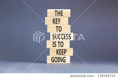 Success and keep going symbol. Concept words The key to success is to keep going on beautiful wooden blocks. Beautiful grey paper background. Business success and keep going concept. Copy space. 139599119