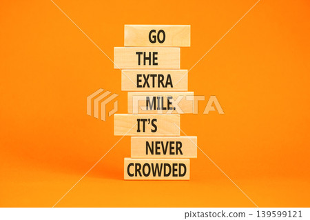 Go the extra mile symbol. Concept words Go the extra mile. It's never crowded on beautiful wooden blocks. Beautiful orange paper background. Business go the extra mile concept. Copy space. Go the extra mile symbol. Concept words Go the extra mile. It's never crowded on beautiful wooden blocks. Beautiful orange paper background. Business go the extra mile concept. Copy space. 139599121