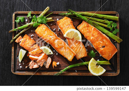 fried salmon with asparagus and lemon on a board 139599147