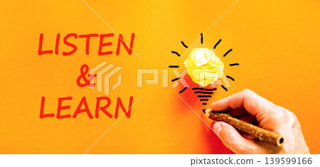 Listen and learn symbol. Concept words Listen and learn on beautiful orange paper. Beautiful orange background. Light bulb icon. Businessman hand. Business listen and learn support concept. Copy space 139599166