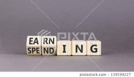 Earning or spending symbol. Concept words Spending to Earning on beautiful wooden cubes. Beautiful grey table grey background. Business and earning or spending concept. Copy space. Earning or spending symbol. Concept words Spending to Earning on beautiful wooden cubes. Beautiful grey table grey background. Business and earning or spending concept. Copy space. 139599227