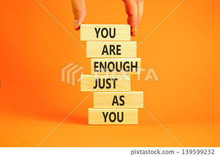 You are enough symbol. Concept words You are enough just as you on beautiful wooden sticks. Beautiful orange background. Business motivational and you are enough just as you concept. Copy space. You are enough symbol. Concept words You are enough just as you on beautiful wooden sticks. Beautiful orange background. Business motivational and you are enough just as you concept. Copy space. 139599232