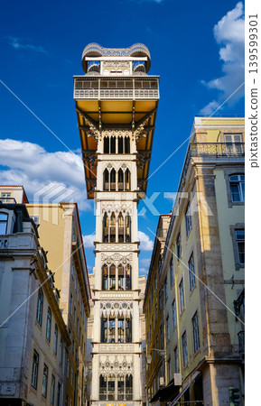 View of Santa Justa Lift or Carmo lift elevator in historic center, Lisbon, Portugal connecting Baixa district with Largo do Carmo on sunny day. Iron tower, blue sky with clouds, iconic city landmark 139599301
