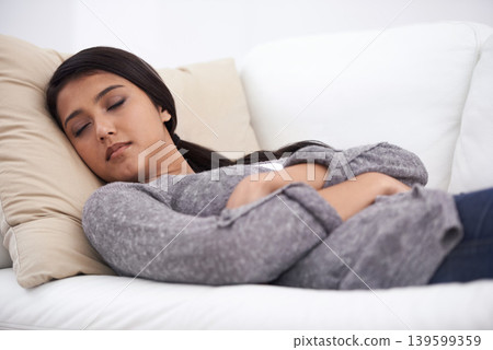 Sleeping, woman and sofa in the morning break with rest, fatigue and nap in a home. Tired female person, couch and relax in a lounge with dreaming, house and living room with peace, sleepy and calm 139599359
