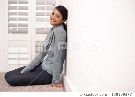 Woman, portrait and smile in a new home on the floor and carpet relax in the morning. Lounge, happy and female person from India with mockup space, real estate and calm in a house by a room wall Woman, portrait and smile in a new home on the floor and carpet relax in the morning. Lounge, happy and female person from India with mockup space, real estate and calm in a house by a room wall 139599377