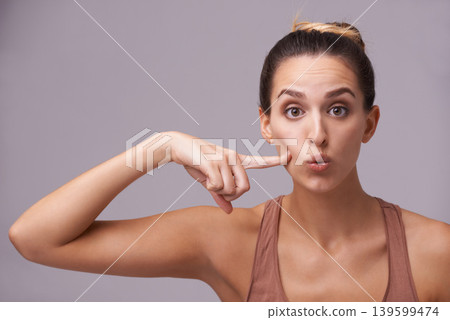 Portrait, beauty and finger on cheek with woman in studio on gray background for dermatology or cosmetics. Face, skincare and spa with natural young person pointing to mouth for wellness or facial Portrait, beauty and finger on cheek with woman in studio on gray background for dermatology or cosmetics. Face, skincare and spa with natural young person pointing to mouth for wellness or facial 139599474