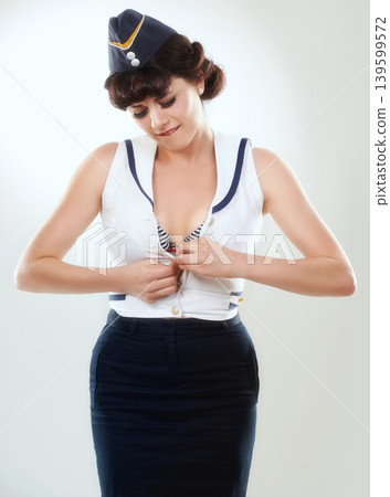 Flight attendant, button shirt and a young woman in studio isolated on white background. Air hostess, pin up girl and stewardess, retro fashion model or vintage sailor in clothes to travel on journey Flight attendant, button shirt and a young woman in studio isolated on white background. Air hostess, pin up girl and stewardess, retro fashion model or vintage sailor in clothes to travel on journey 139599572