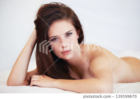 Woman, bed and topless in portrait with lingerie, relax and holiday with calm in apartment, hotel or home. Girl, person and lying in bedroom, house and wake up on cover, duvet and underwear with body 139599670