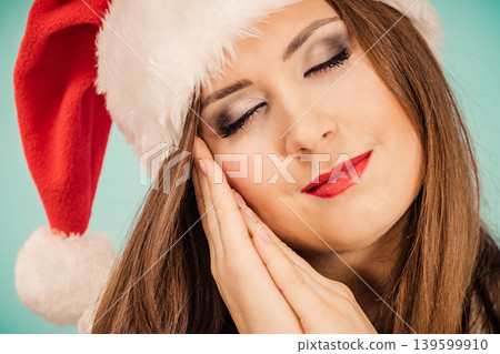 Woman in santa hat being sleepy 139599910