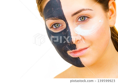 Girl black mask on half face apply white mud Girl black mask on half face apply white mud 139599923