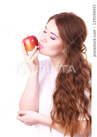 Woman holding apple fruit close to face 139599935