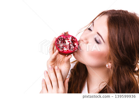 Cheerful woman holds pomegranate fruits, isolated Cheerful woman holds pomegranate fruits, isolated 139599936