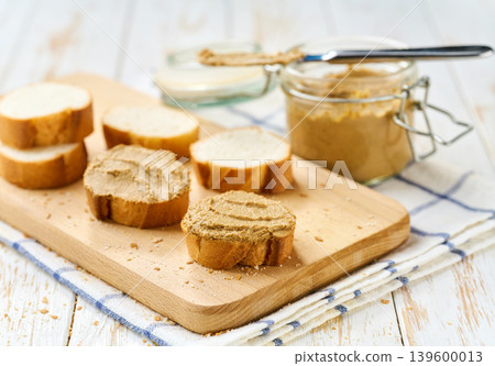 Natural gourmet liver pate spread on a white wooden table, selective focus. Natural gourmet liver pate spread on a white wooden table, selective focus. 139600013