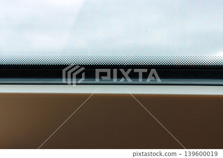 Train window with shallow depth of field, with raindrops on the glass and a foggy view outside and subtle motion blur. Minimal travel detail with atmospheric mood. Copy space Train window with shallow depth of field, with raindrops on the glass and a foggy view outside and subtle motion blur. Minimal travel detail with atmospheric mood. Copy space 139600019