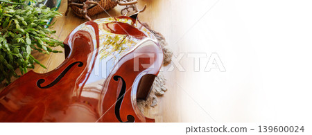 Close up of a damaged contrabass body with broken neck lying on the floor with copy space banner 139600024