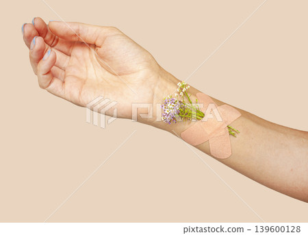 Medical Plaster with flowers on hand. Hand with a medical patch. Medical Plaster with flowers on hand. Hand with a medical patch. 139600128