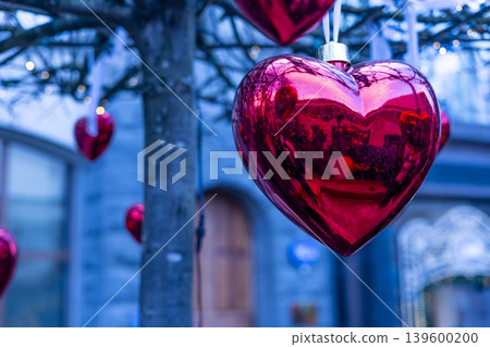 A red heart ornament hangs on a tree 139600200