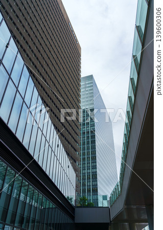 Tokyo, Japan - Oct 01 2024, vertical view of glass skyscraper facades against a cloudy sky in the Chiyoda district, at daytime, Tokyo, Japan 139600306
