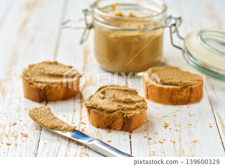 patecurls on a slice of baguette bread on a white table, selective focus. 139600329