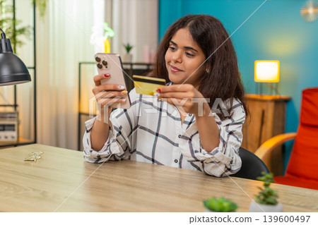 Indian woman entering credit card on smartphone reviewing payment checkout process online secure Indian woman entering credit card on smartphone reviewing payment checkout process online secure 139600497