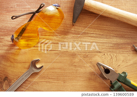 Working tools on wooden background. glasses, pliers, hammer, screwdriver. construction, repair concept Working tools on wooden background. glasses, pliers, hammer, screwdriver. construction, repair concept 139600589