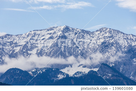 Snow capped Bavarian Alps mountain range with soft clouds in spring sky Snow capped Bavarian Alps mountain range with soft clouds in spring sky 139601080