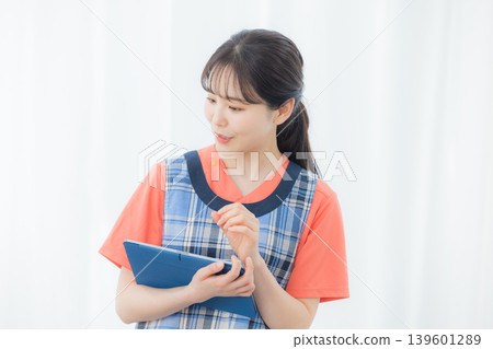 A woman with an apron with a tablet 139601289