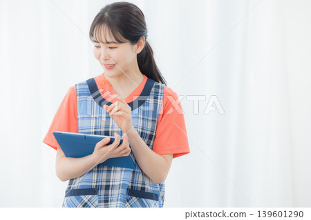 A woman with an apron with a tablet 139601290